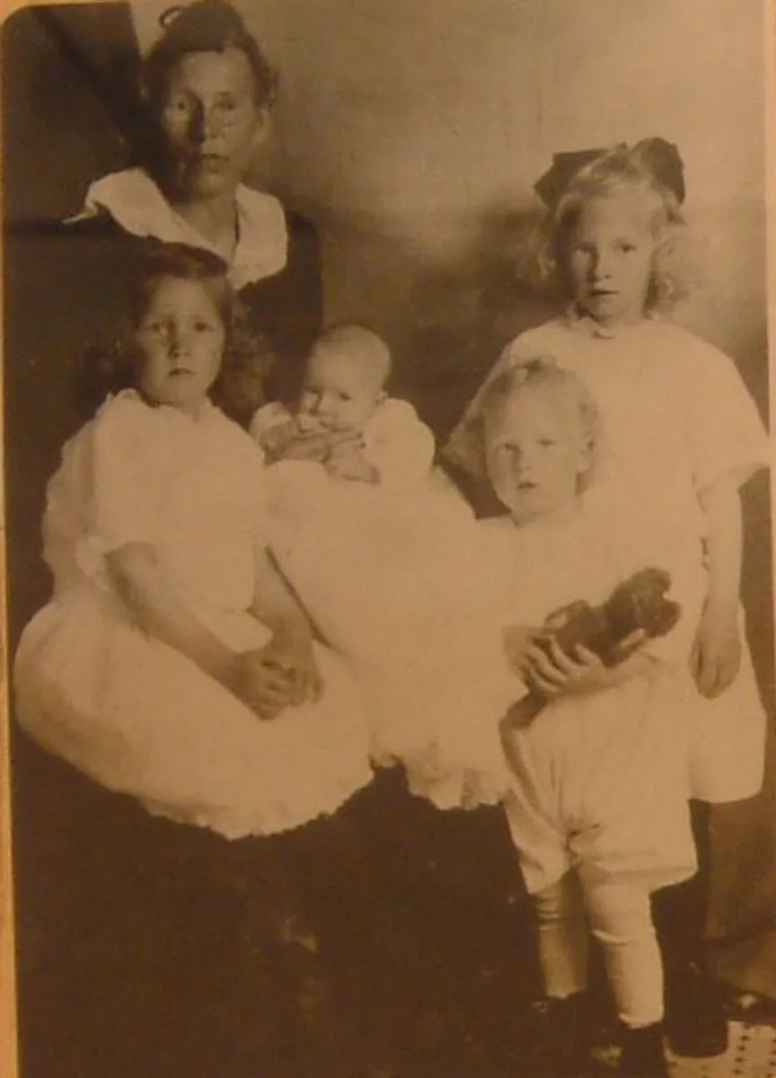 Before: sepia studio portrait of a woman with four young children in white dresses