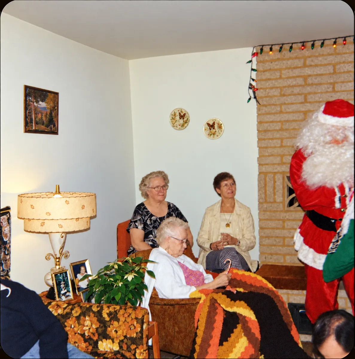 After: faded color photo of family members in a living room with Santa Claus