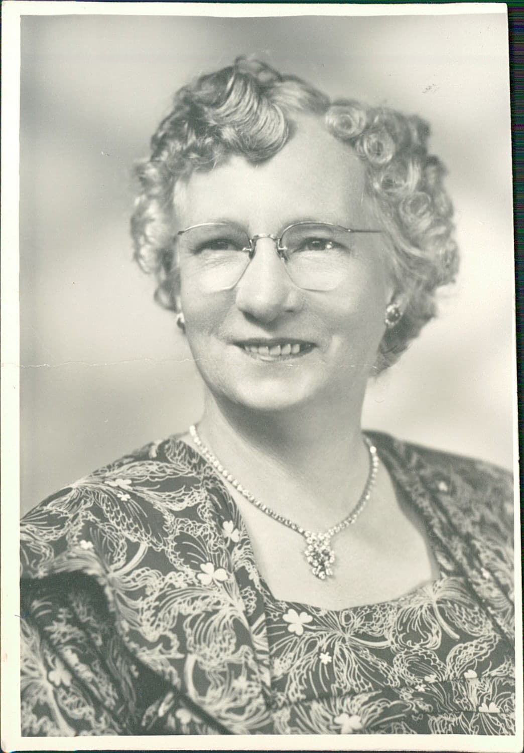 Faded black-and-white portrait of an elderly woman before AI restoration.