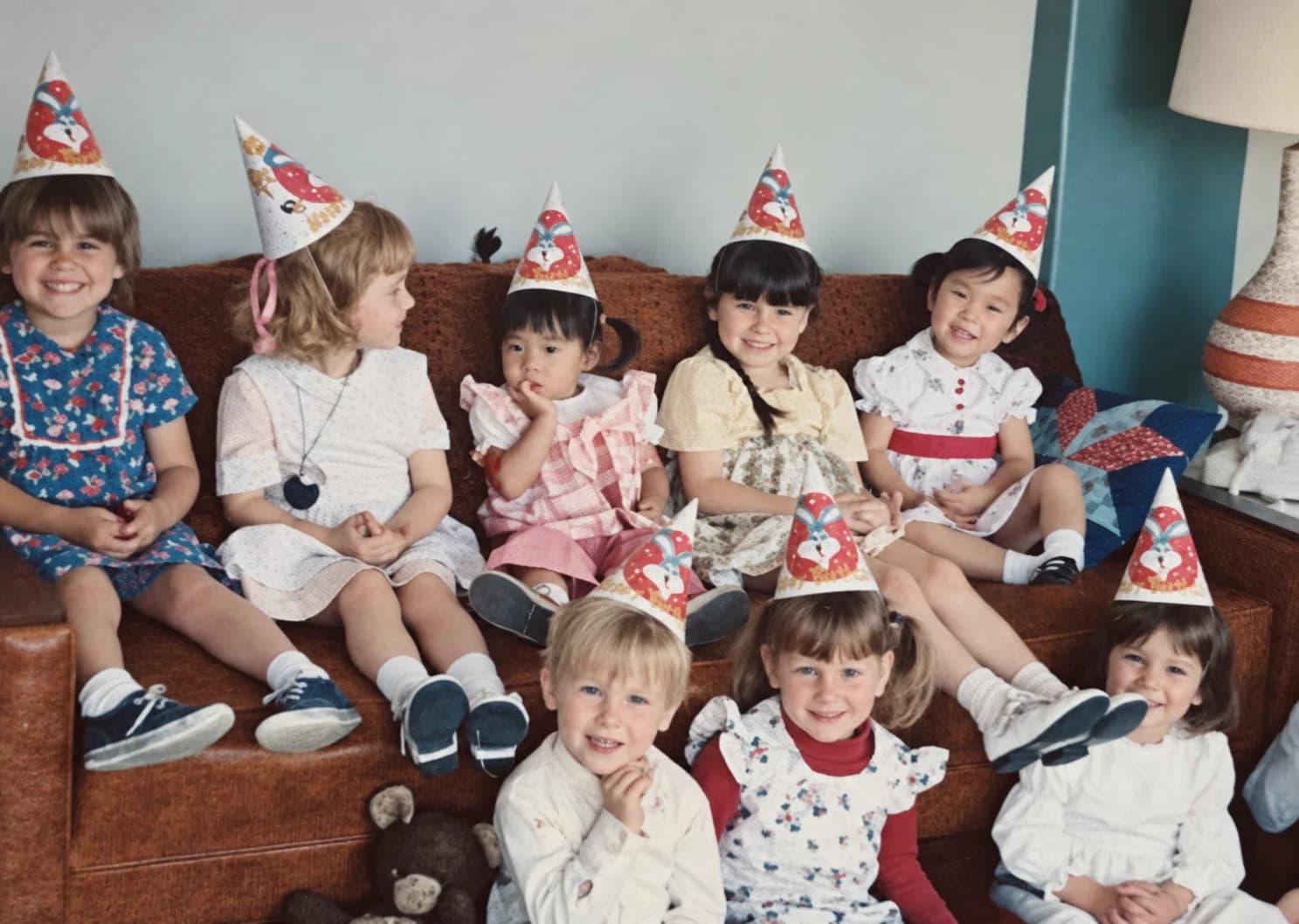 Full Restore: faded color snapshot of children in party hats sitting on a couch